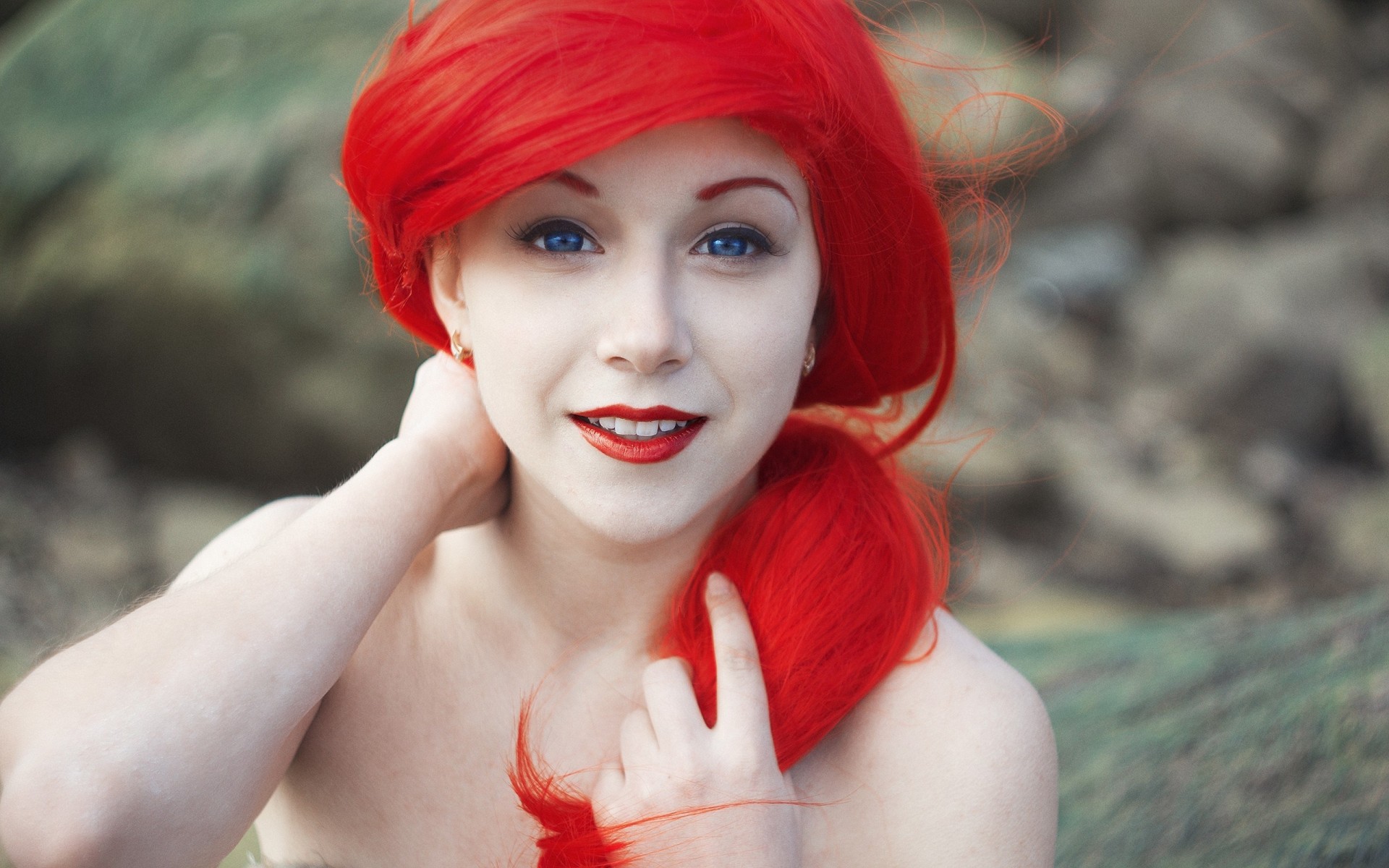 Эротические фото рыжей девушки с красным цветком в волосах на природе