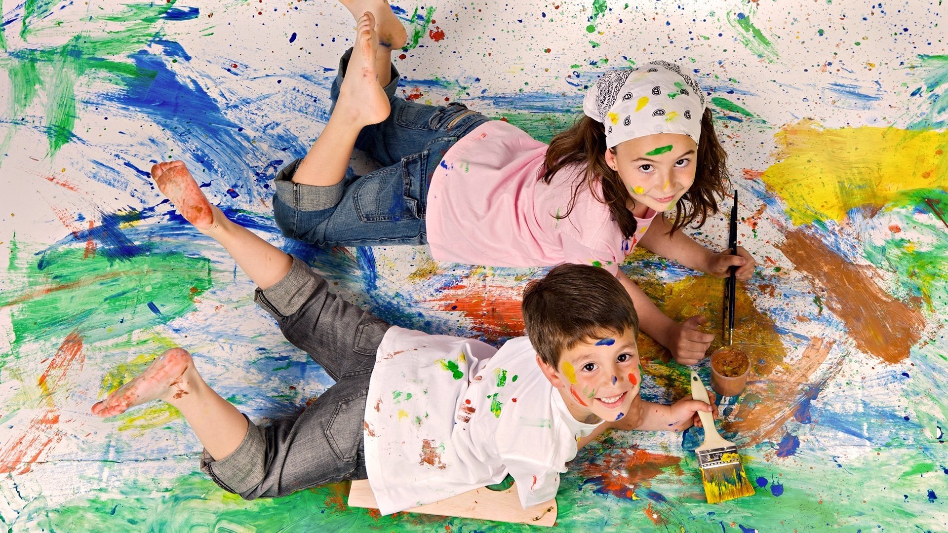 artistas adolescentes todo en pintura mirada sonrisa niños niña niño dos bromas pintura pinceles juegos
