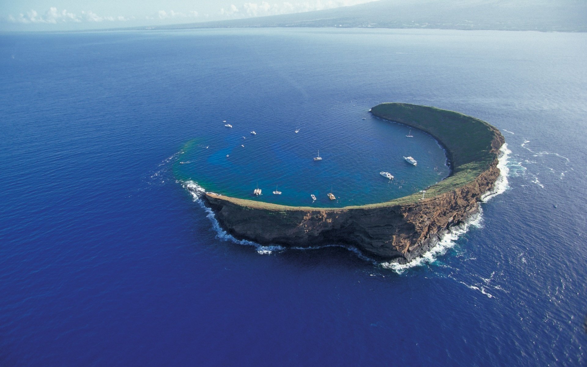 forma della luna sottile catena montuosa barche acqua isole vista paesaggio altezza onde baia distesa superficie liscia blu natura estate