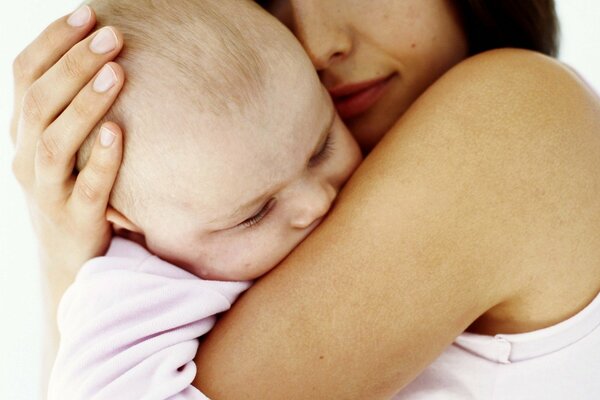 Le bébé qui dort dans les bras de sa mère. Tendresse maternelle