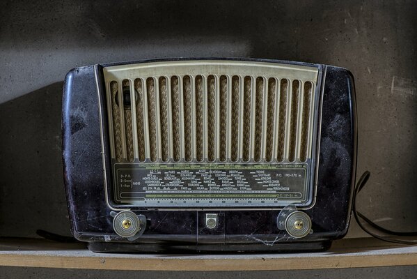 An old radio receiver against a gray wall