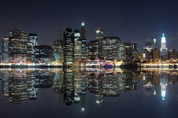 The night metropolis is reflected in the surface of the river