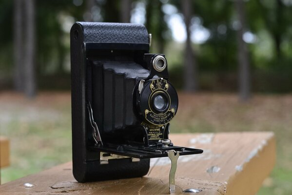 Старинная фотокамера на скамейке