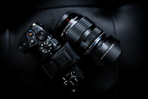 Olympus-Kamera mit liegendem Objektiv auf dunklem Hintergrund