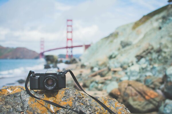 Fotocamera canon su una pietra sullo sfondo del Golden Gate Bridge