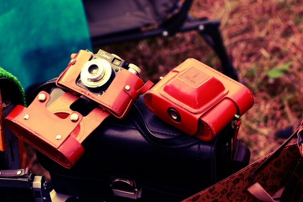 Tre fotocamere rosse poggiano sulla borsa