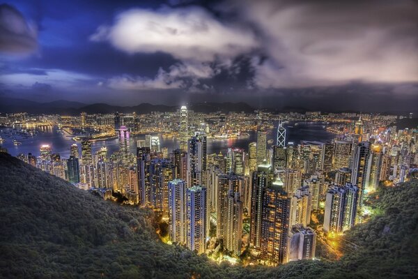 View of the night city from above in the light of a thunderstorm and rare glowing windows