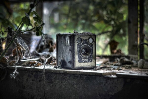 Retro camera on the background of an abandoned house