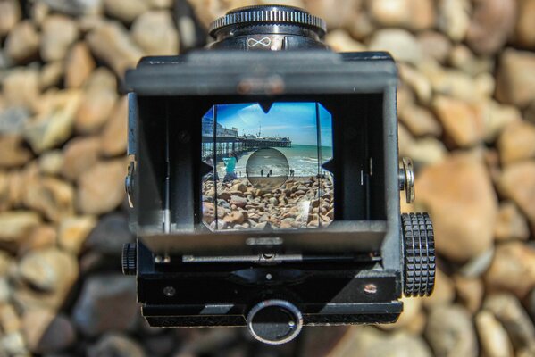 Vecchia macchina fotografica su uno sfondo di pietre di mare