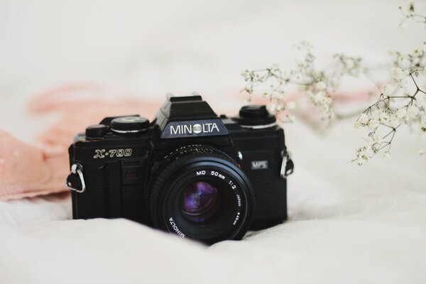 Kamera Minolta na białej narzutce