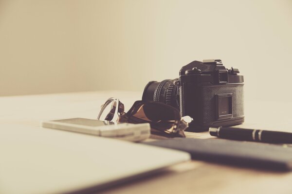 Marcus Spiske camera on the background of glasses, smartphone and pen