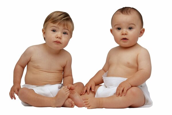 Two babies in diapers are watching carefully