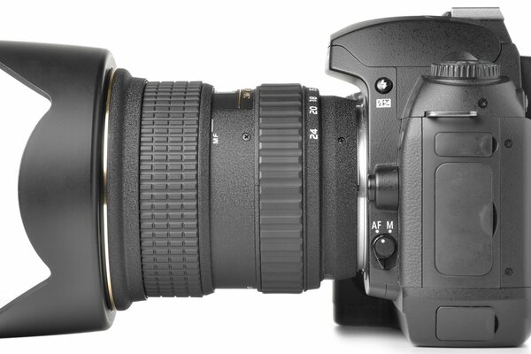 On a white background, a professional camera with a long-focus lens