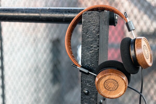 Los auriculares de madera cuelgan de la cerca