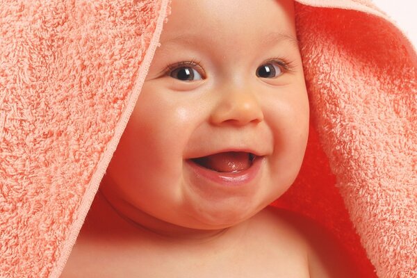 Glückliches Baby nach dem Baden mit Spielzeug
