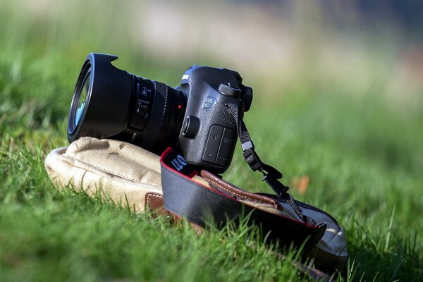 A camera with a large lens on the grass