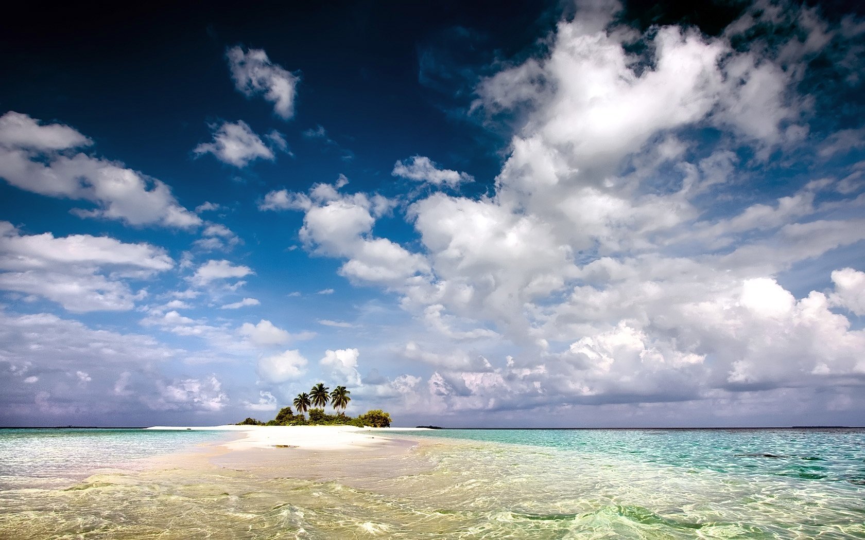 kawałek ziemi bezludna wyspa palmy fale morza niebo chmury ocean krajobraz natura widok