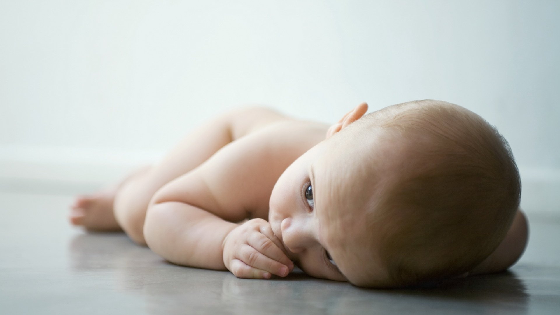 petit terne couché sur le sol nu regard enfant bébé miette couché