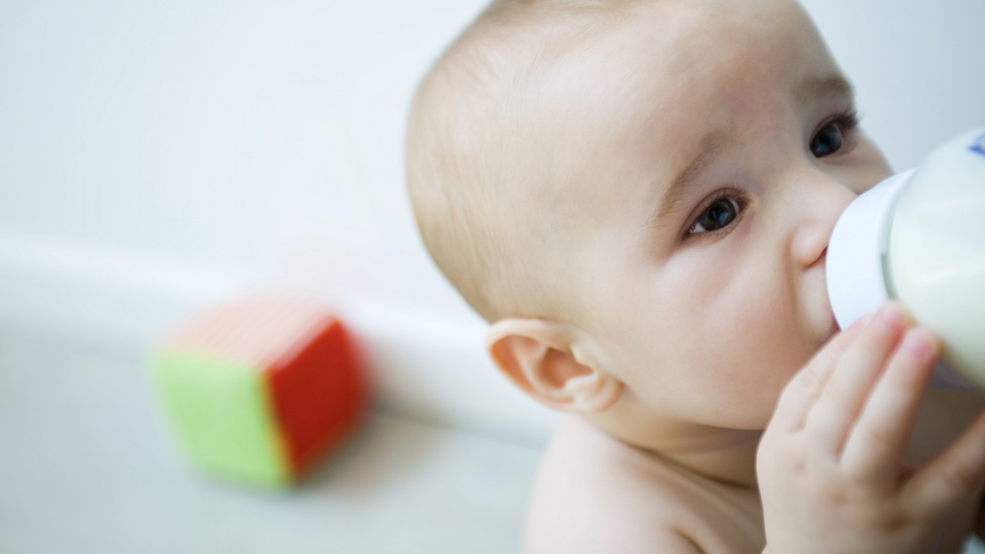 bettelnde augen trinkt milch kind porträt blick augen gesicht würfel spielzeug fütterung milch flasche krümel kind augen