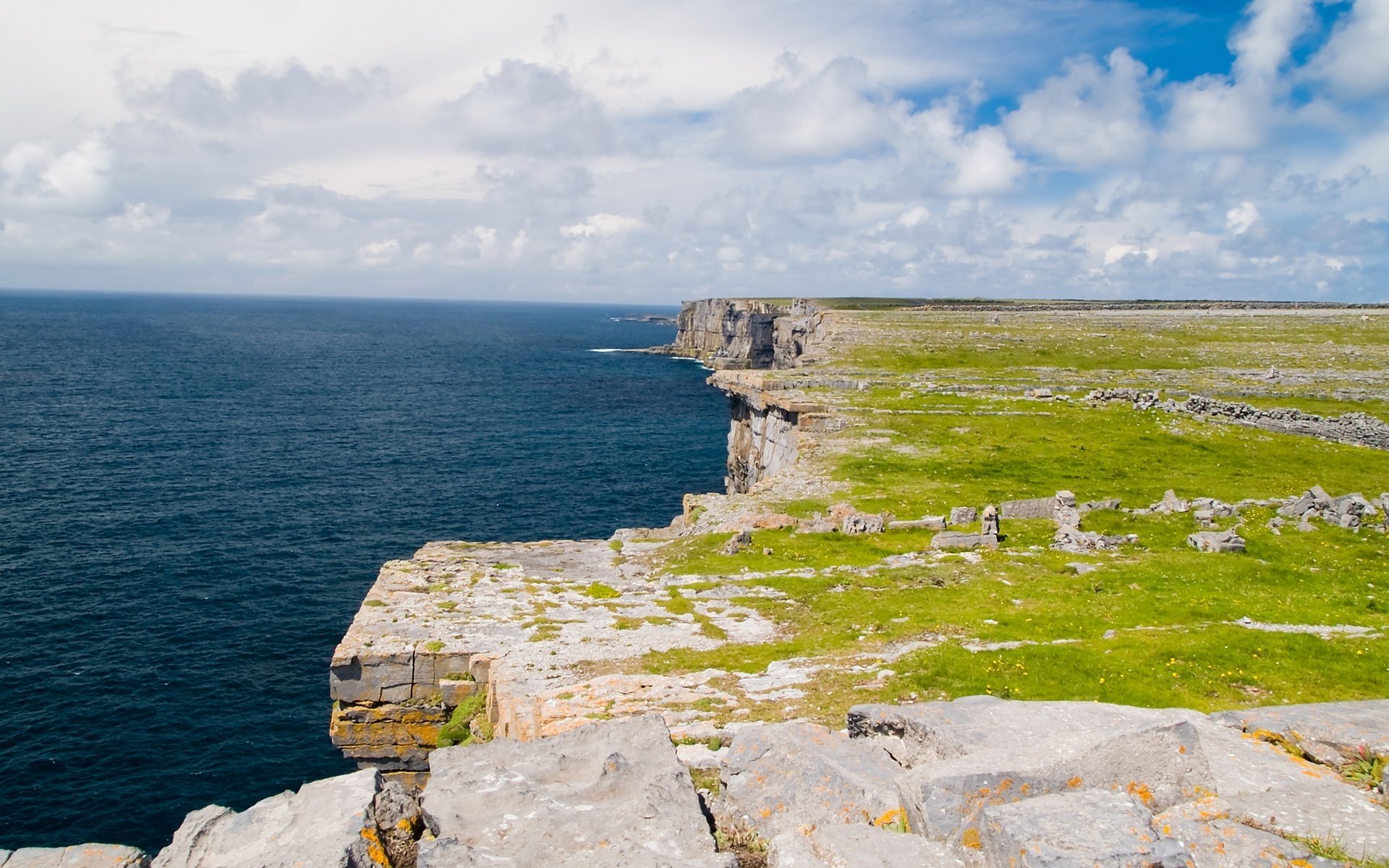 mountain cliff water blue water sky sea massif relief horizon nature clouds landscape