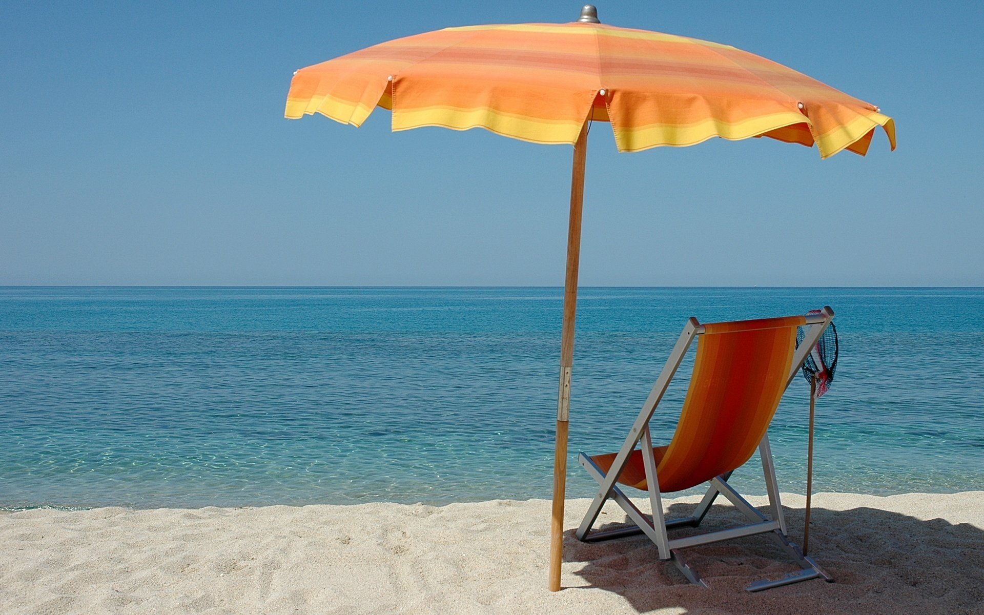 sonnenliege regenschirm ruhiges meer strand wasser meer glatte oberfläche horizont landschaft natur urlaub urlaub resort sand sommer hitze hitze