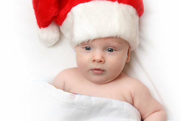 Petit enfant dans le chapeau du père Noël