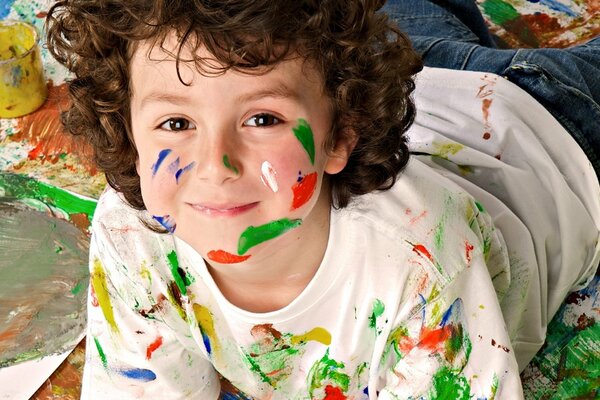 Curly-haired boy in paint as an artist