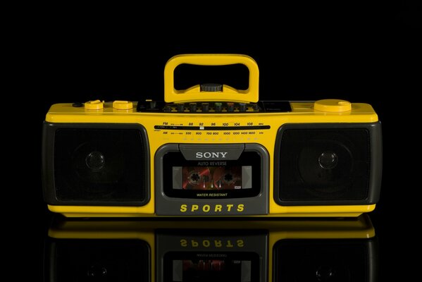 Classic retro yellow tape recorder on a black background