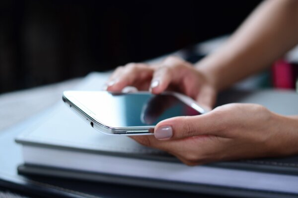 La jeune fille tient dans ses mains un iPhone