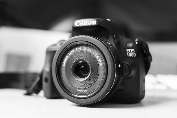 Canon camera is on the table, black and white photo