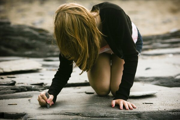 La ragazza disegna sull asfalto con il gesso