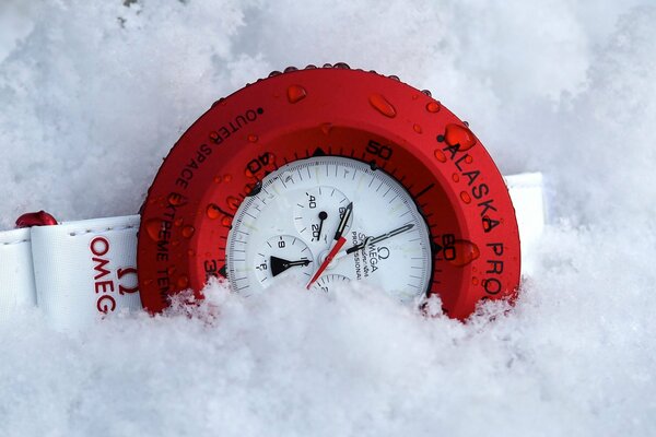 Orologio rosso sulla neve bianca, ottima combinazione di colori