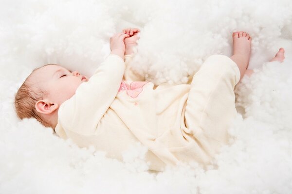 Sweet dream of a baby in the clouds of a blanket