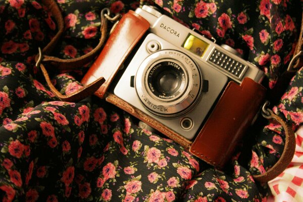 Macchina fotografica d epoca su tessuto floreale