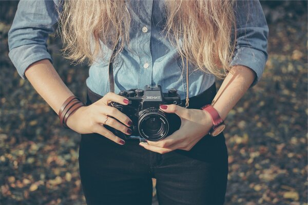 Una chica con una cámara retro Zenit en sus manos
