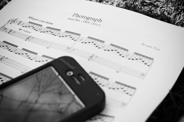 Smartphone on a sheet with notes in a black and white filter