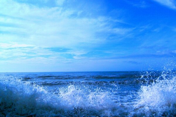 Spruzzi d acqua durante il surf su uno sfondo di cielo blu