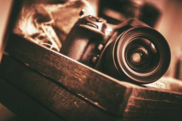 The camera is in a wooden box. Macro photo in sepia