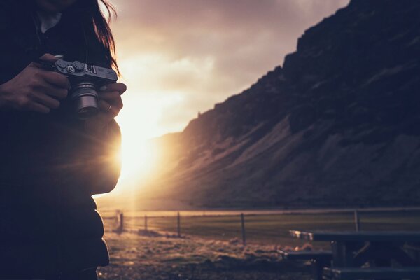 Macchina fotografica sullo sfondo di montagna e tramonto