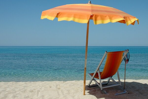 Chaise longue avec parasol sur la plage