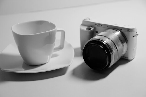 Appareil photo et tasse à café sur la soucoupe