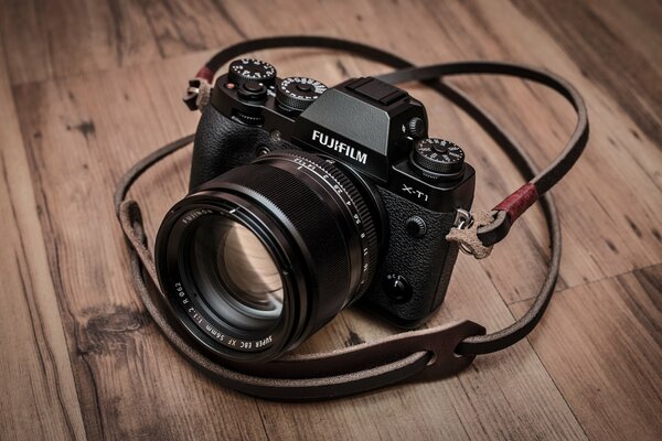 A black camera on a wooden table