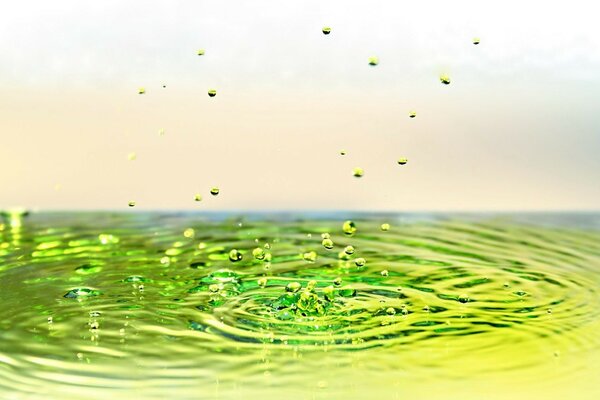 Gotas verdes caen del agua amarilla