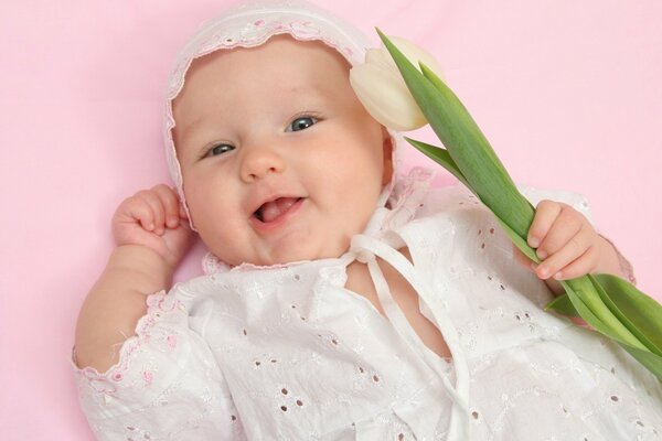 Charming little girl with a white tulip