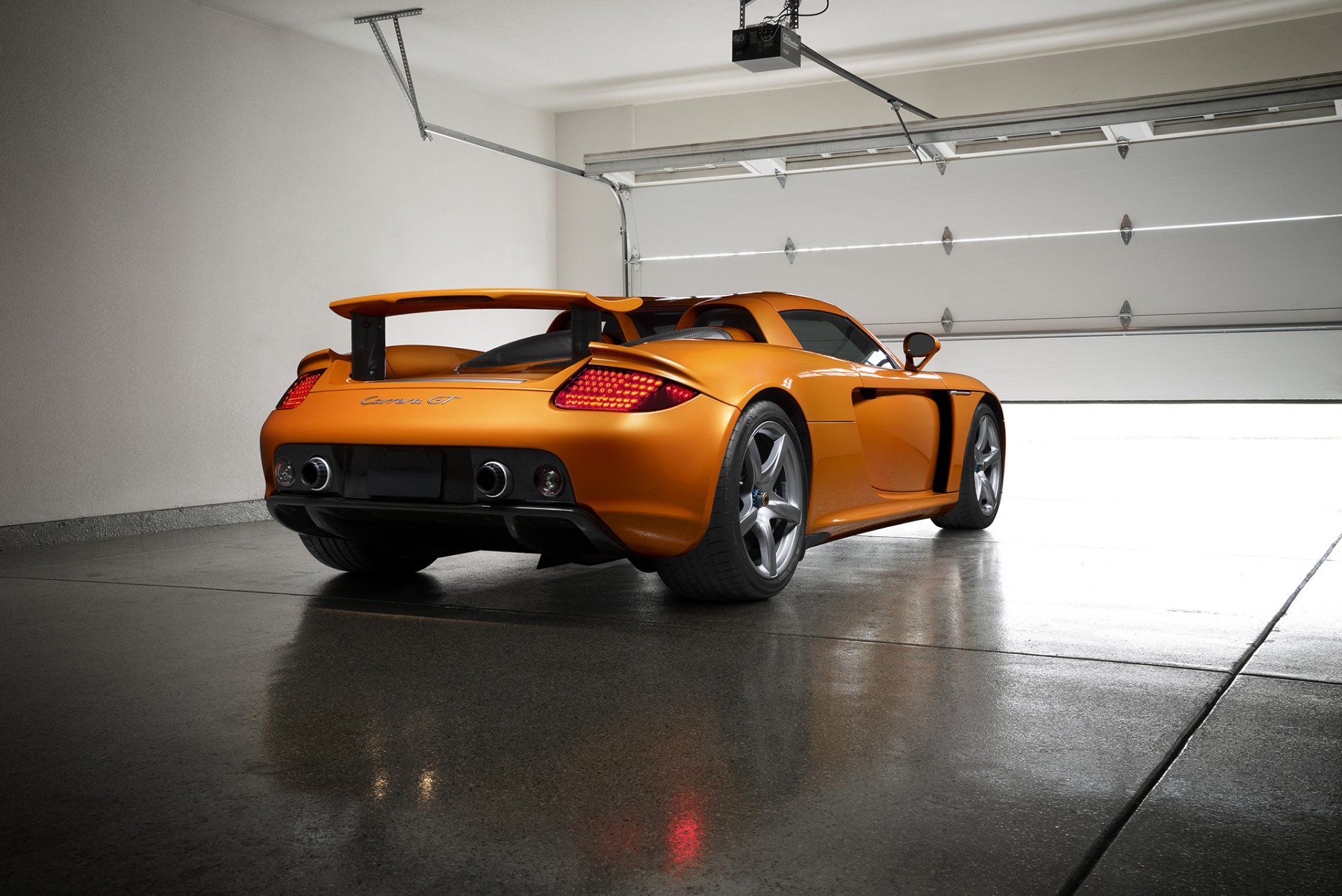 porsche carrera gt orange borealis exotisch supersportwagen licht nigth hinten garage