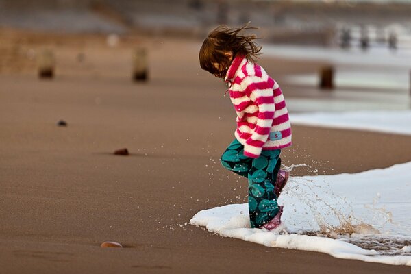 A girl in the sea surf wet her feet