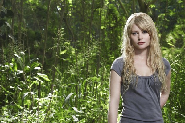 Jolie fille blonde dans la forêt sombre