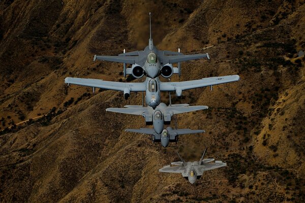 F-16, f - 22, f - 15 fighters in the sky over the hills