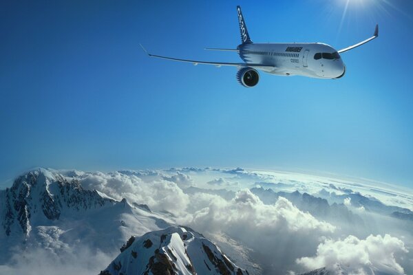 The plane on the background of the blue sky, flying over the snowy mountains