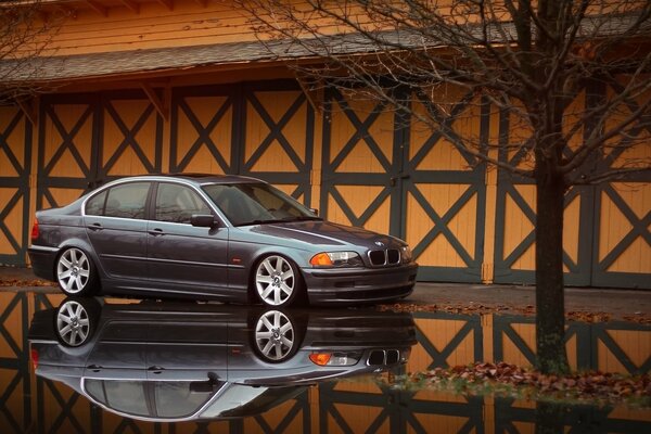 BMW gris con reflejo en charco